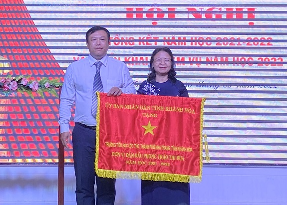 Đại diện Sở Nội vụ trao cờ thi đua của UBND tỉnh cho Trường Tiểu học Lộc Thọ. 