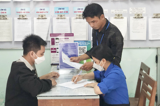 Công chức xã Khánh Hiệp hỗ trợ người dân viết tờ khai  xin trích lục bản sao giấy khai sinh.