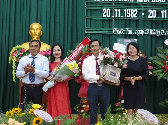 Đại diện lãnh đạo địa phương và ban đại diện cha mẹ học sinh trường tặng hoa chúc mừng lãnh đạo nhà trường. 