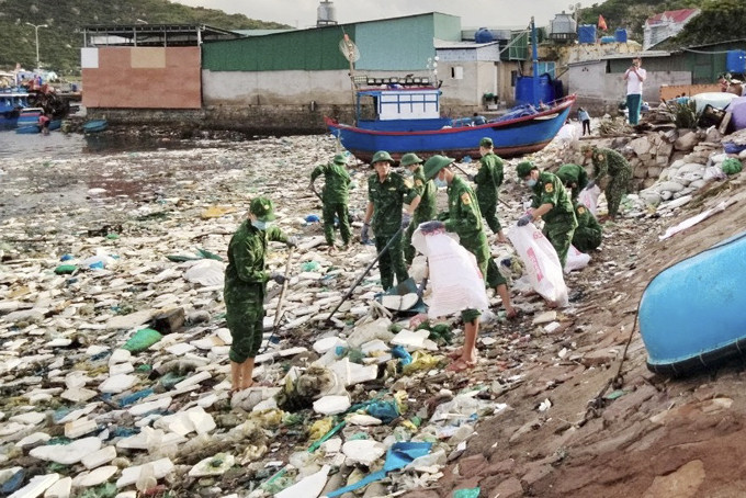 Cán bộ, chiến sĩ thu gom rác thải dọc bãi biển.