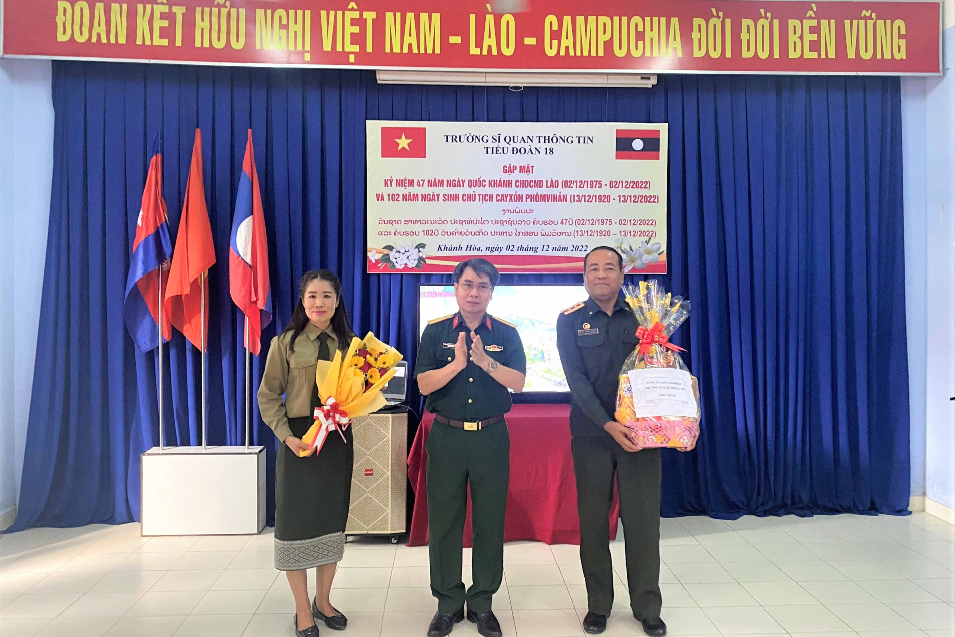 Thủ trưởng Trường Sĩ quan Thông tin tặng hoa chúc mừng đại diện cán bộ, học viên Quân đội Nhân dân Lào đang học tập tại nhà trường