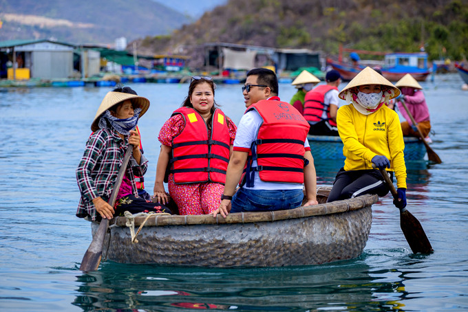 Khách du lịch  đi thuyền thúng tham quan  nuôi trồng thủy sản trên vịnh Nha Trang.