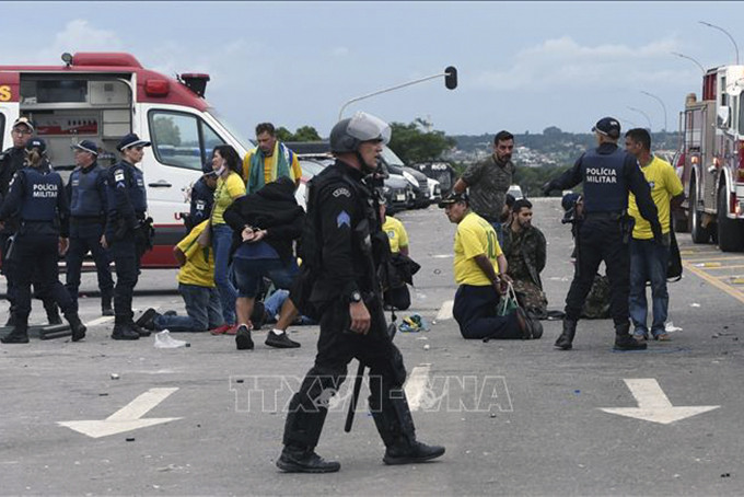 Lực lượng an ninh Brazil bắt giữ các đối tượng biểu tình đột nhập vào Dinh Tổng thống tại Brasilia ngày 8/1/2023. Ảnh: AFP/TTXVN