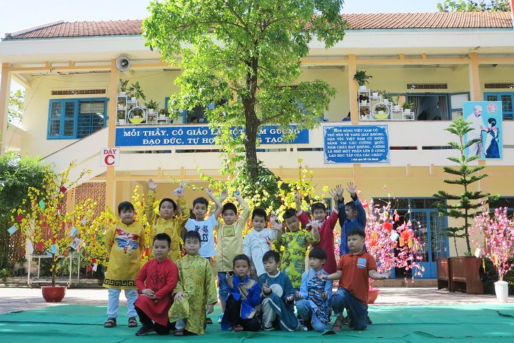 Các học sinh trong trang phục áo dài truyền thống chụp ảnh lưu niệm tại lễ hội xuân. 