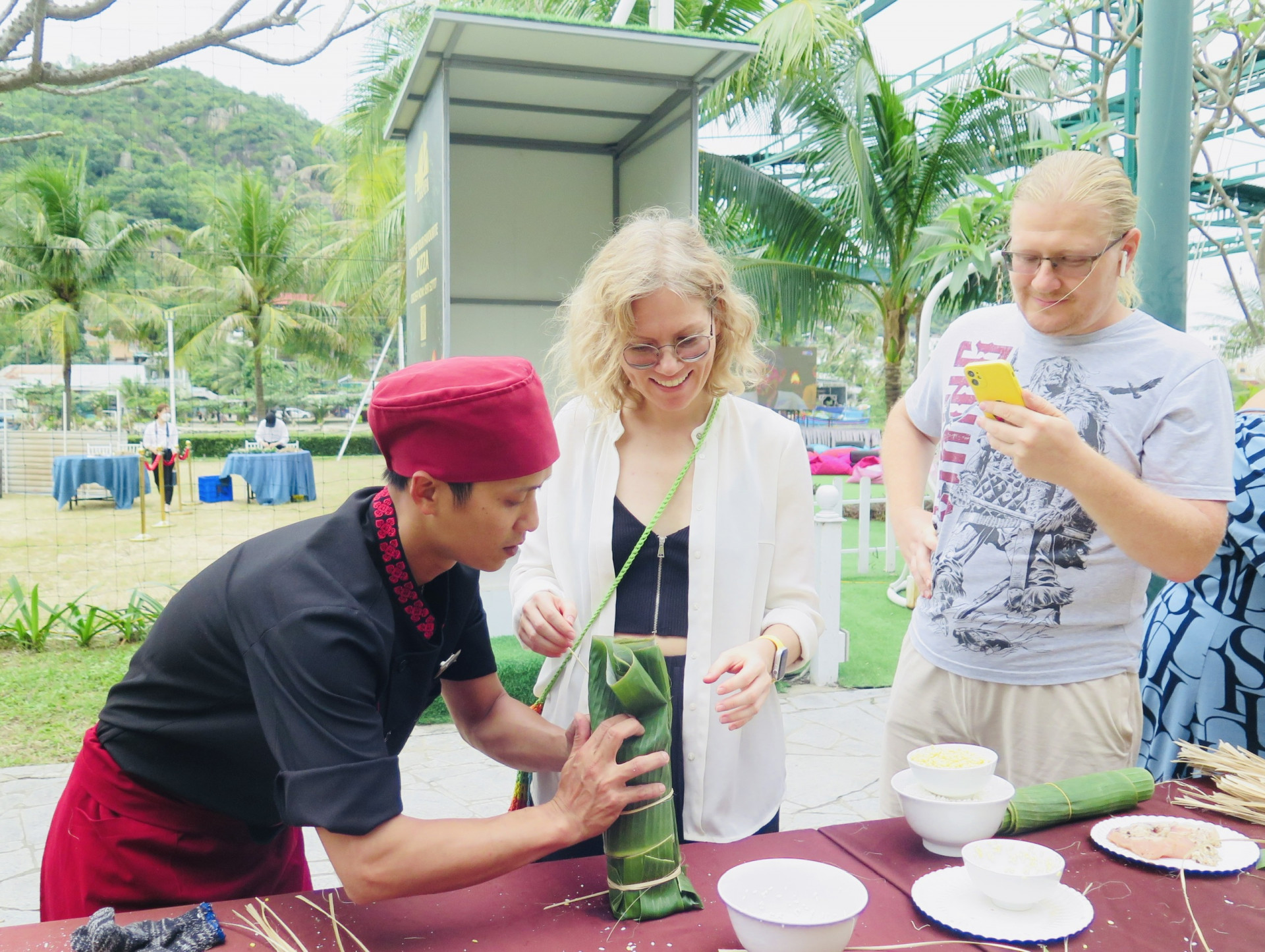 Nhân viên Champa Island hỗ trợ du khách nước ngoài gói bánh Tét