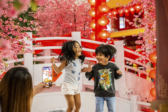 Trẻ em tạo dáng chụp ảnh với đồ trang trí Tết Nguyên đán tại một trung tâm mua sắm ở Kuala Lumpur, Malaysia ngày 18/1. Ảnh: Xinhua