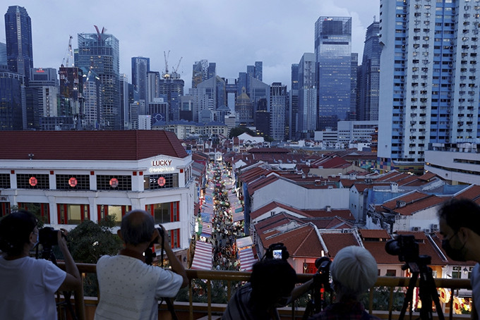 Chụp ảnh đám đông mua sắm tại khu phố người Hoa dịp Tết Nguyên đán ở Singapore ngày 18/1. Ảnh: Reuters