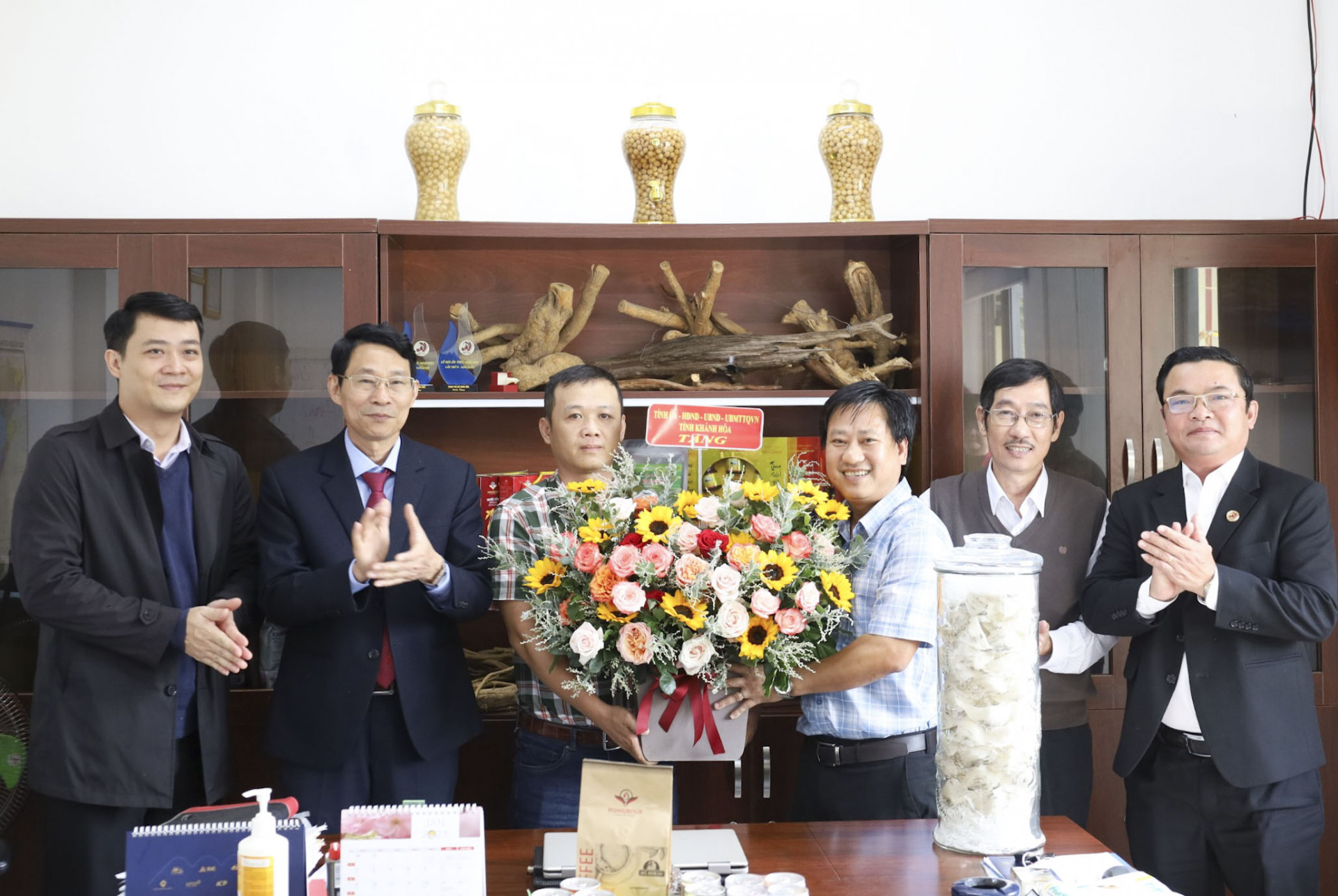 Ông Đinh Văn Thiệu (thứ 2 từ trái qua) tặng hoa chúc mừng Công ty Cổ phần POMGROUP .