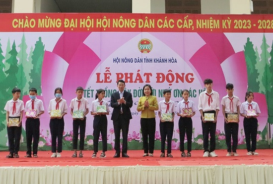 Ông Đinh Văn Thiệu và lãnh đạo Hội Nông dân tỉnh trao quà cho các học sinh. 