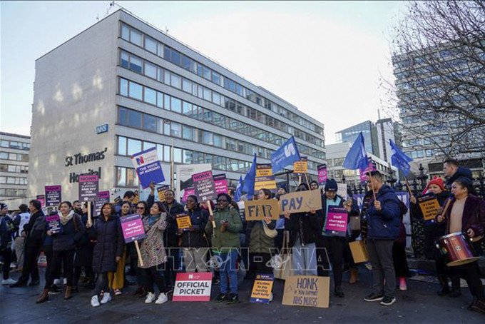 Nhân viên y tế tham gia đình công yêu cầu tăng lương bên ngoài bệnh viện St Thomas' ở London, Anh, ngày 20/12/2022. Ảnh tư liệu: AFP/TTXVN