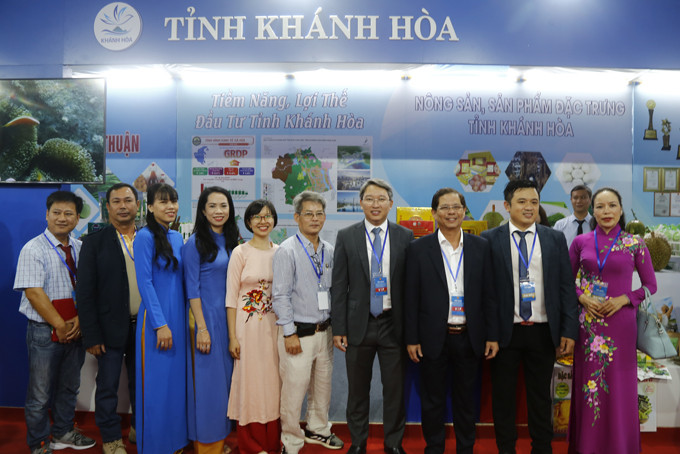 Lãnh đạo tỉnh chụp hình lưu niệm cùng đại diện các doanh nghiệp tại gian hàng giới thiệu về tỉnh Khánh Hòa.