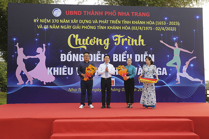 Ông Phan Thanh Liêm-Phó Chủ tịch UBND TP. Nha Trang trao hoa và cờ lưu niệm cho các đơn vị tham gia chương trình.