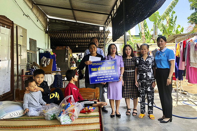 Đại diện Trung tâm Điều dưỡng và Chăm sóc người có công - Công tác xã hội tỉnh  trao hỗ trợ sinh kế cho mẹ con chị Phạm Thị Hương.