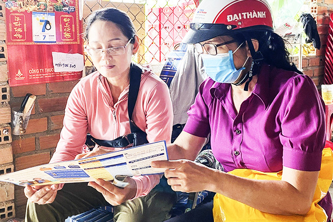 Nhân viên bảo hiểm xã hội (bên phải) tuyên truyền chính sách bảo hiểm y tế,  bảo hiểm xã hội cho người dân xã Ninh Phụng.