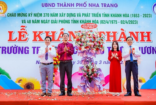 Ông Hồ Văn Mừng và ông Nguyễn Sỹ Khánh - Chủ tịch UBND TP. Nha Trang tặng hoa chúc mừng Trường THCS Trưng Vương. 